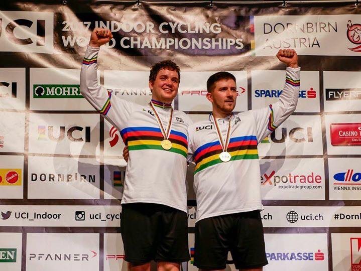 Zwei Personen beim Jubeln auf dem Podest in der Indoor Cycling World Championship.